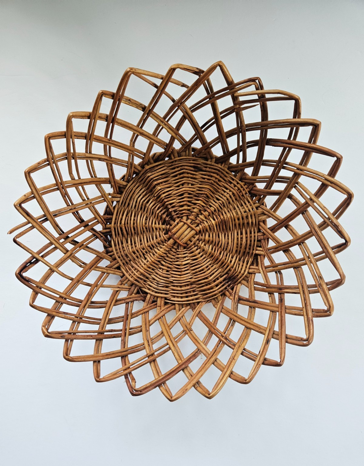 Vintage mid-century rattan wicker basket serving tray from Yugoslavia, used as wall decor.