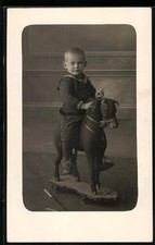 Fotografie Bassler, Oberoderwitz, Knabe im Matrosenanzug auf Spielzeug-Pferd si 