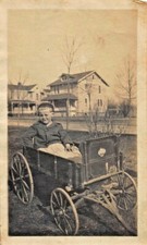 Jeune Garçon Dans Une Charette À Roues En Bois Photographie