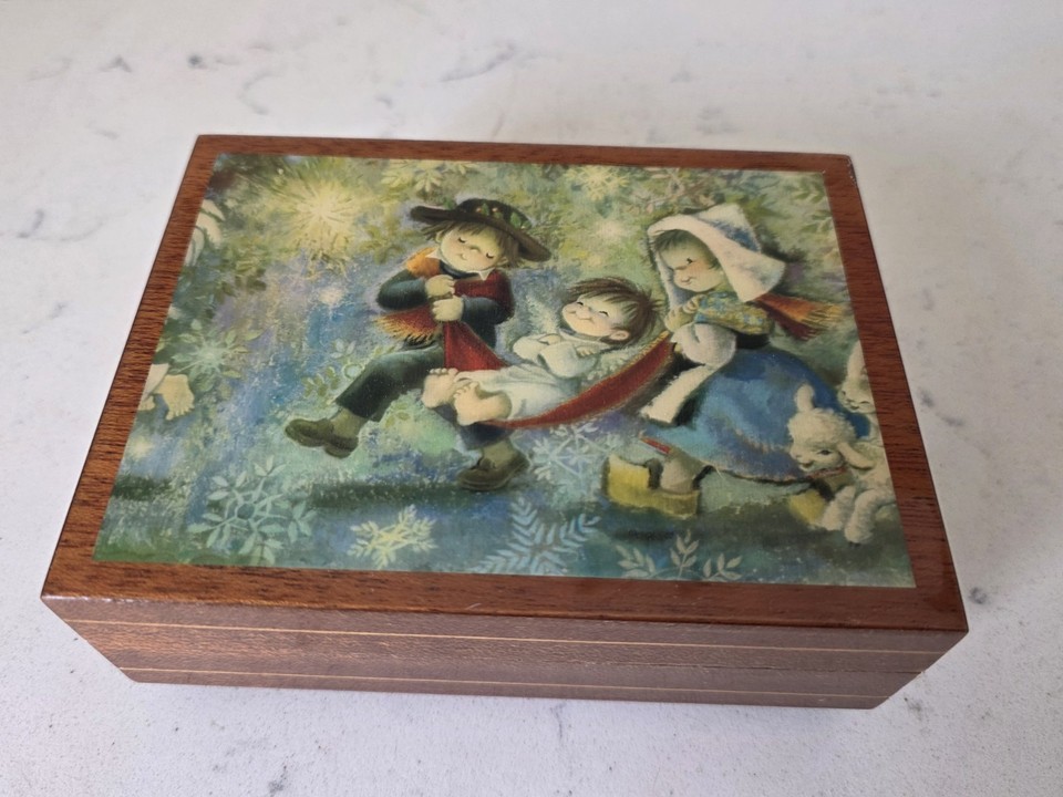 A Reuge Swiss movement playing Edelweiss with a Hummel-style pastoral image — sweet, authentic, and made in Italy with Swiss guts, a genuinely charming vintage trinket.