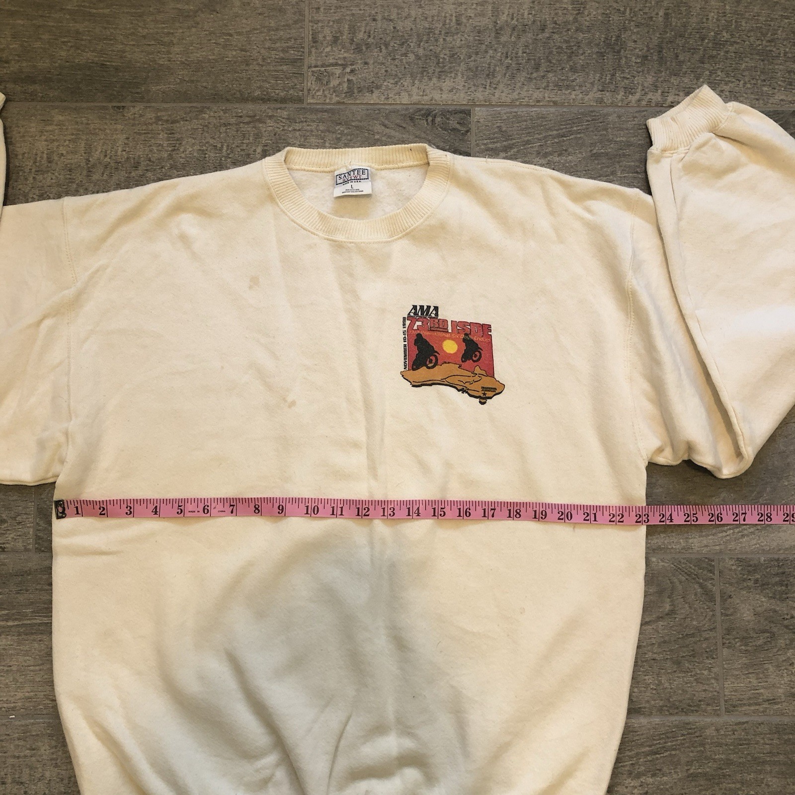 Beige 1998 American Motorbike Assoc sweatshirt with black/red sunset graphic on chest, size L.