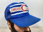 Blue snapback trucker hat with white and white stripes, red “Chicago Cubs” text, and embroidered C logo on the front panel.