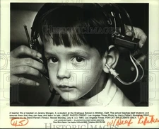 1984 Press Photo Teacher fits headset on Jeremy Morgan so he can hear and talk
