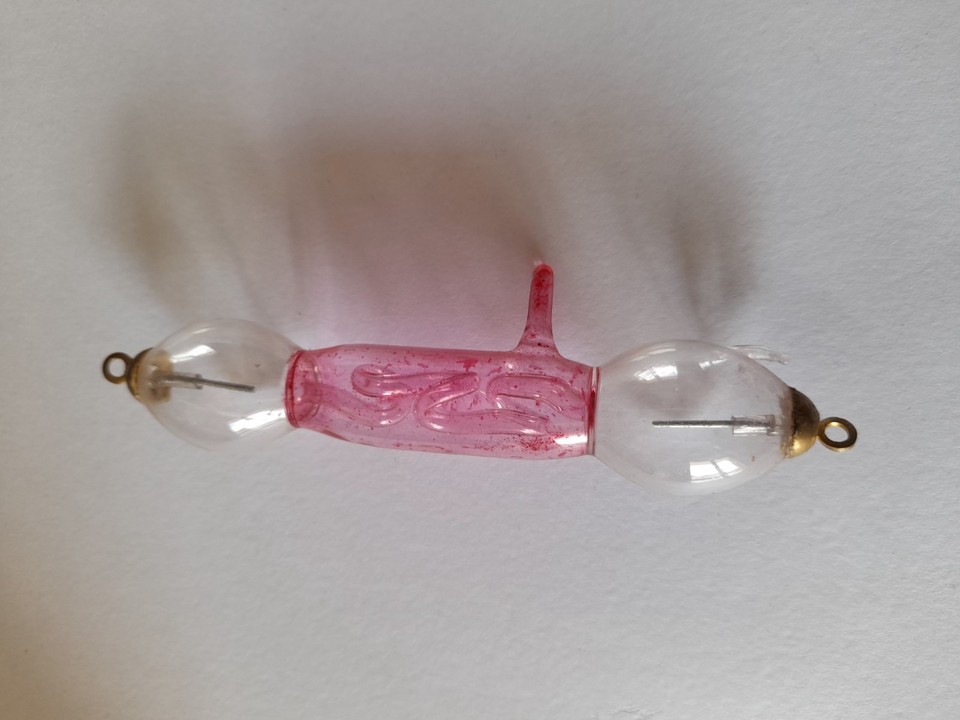 A genuine antique Geissler tube — a 19th-century precursor to neon lights, filled with glowing liquid and pure Victorian mad-scientist energy.
