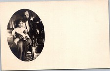 RPPC Seated bearded man holding baby