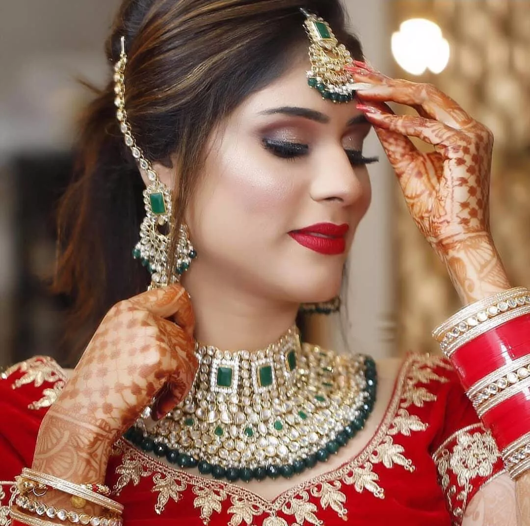 Photo of Bride showing off ring in white and gold engagement lehenga