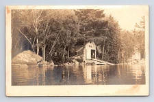 RPPC Unknown Camp Lake-Side Boat Garage American Flag Real Photo Postcard