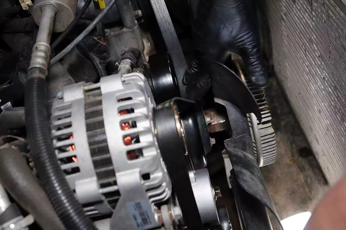 A mechanic replaces the serpentine belt.