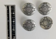 Metal, shank buttons with a black sunburst design. 