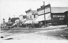 J64/ Seymour Wisconsin RPPC Postcard c1910 Hardware Bakery Meat Store 408
