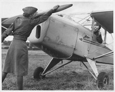 Sergeant prepares to start an airplane's propeller for a pilot in - Old Photo