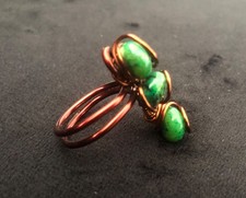 Handcrafted wire-wrapped ring featuring three vibrant green gemstones, vintage