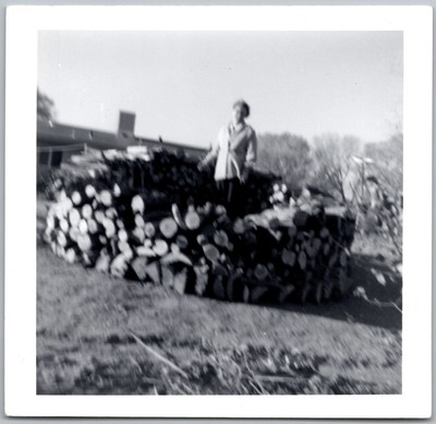 Vtg Snapshot Woman Posing With Enormous Stack Of Cut Firewood Logs 1960