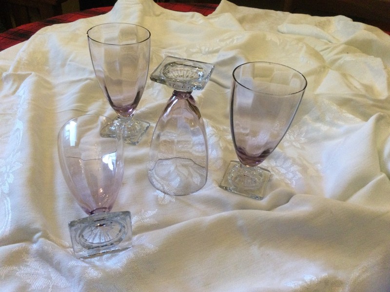 Four pale amethyst goblets or parfait glasses with clear square footed bases