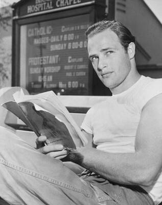 Marlon Brando pictured sitting down reading book outside Hospital C- 1949 Photo