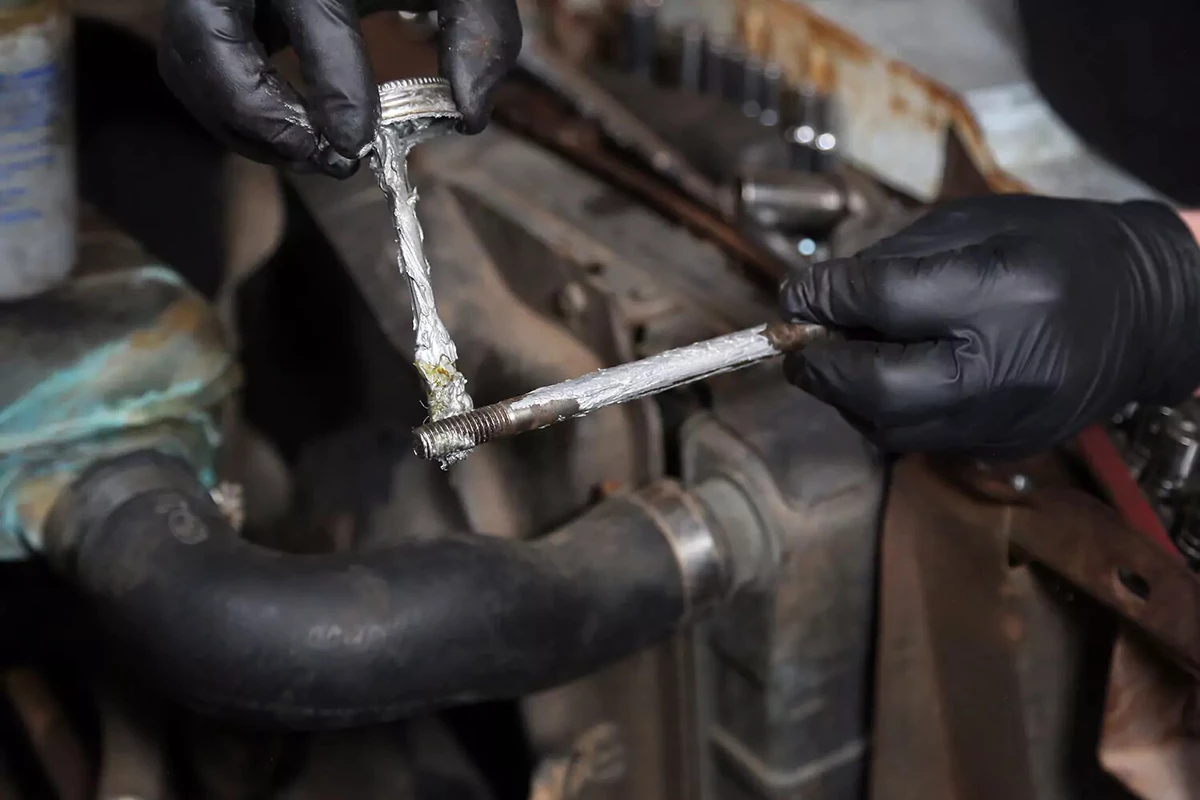 Bolt being coated with anti-seize compound.