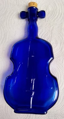 Vintage cobalt blue glass bottle shaped like a violin.