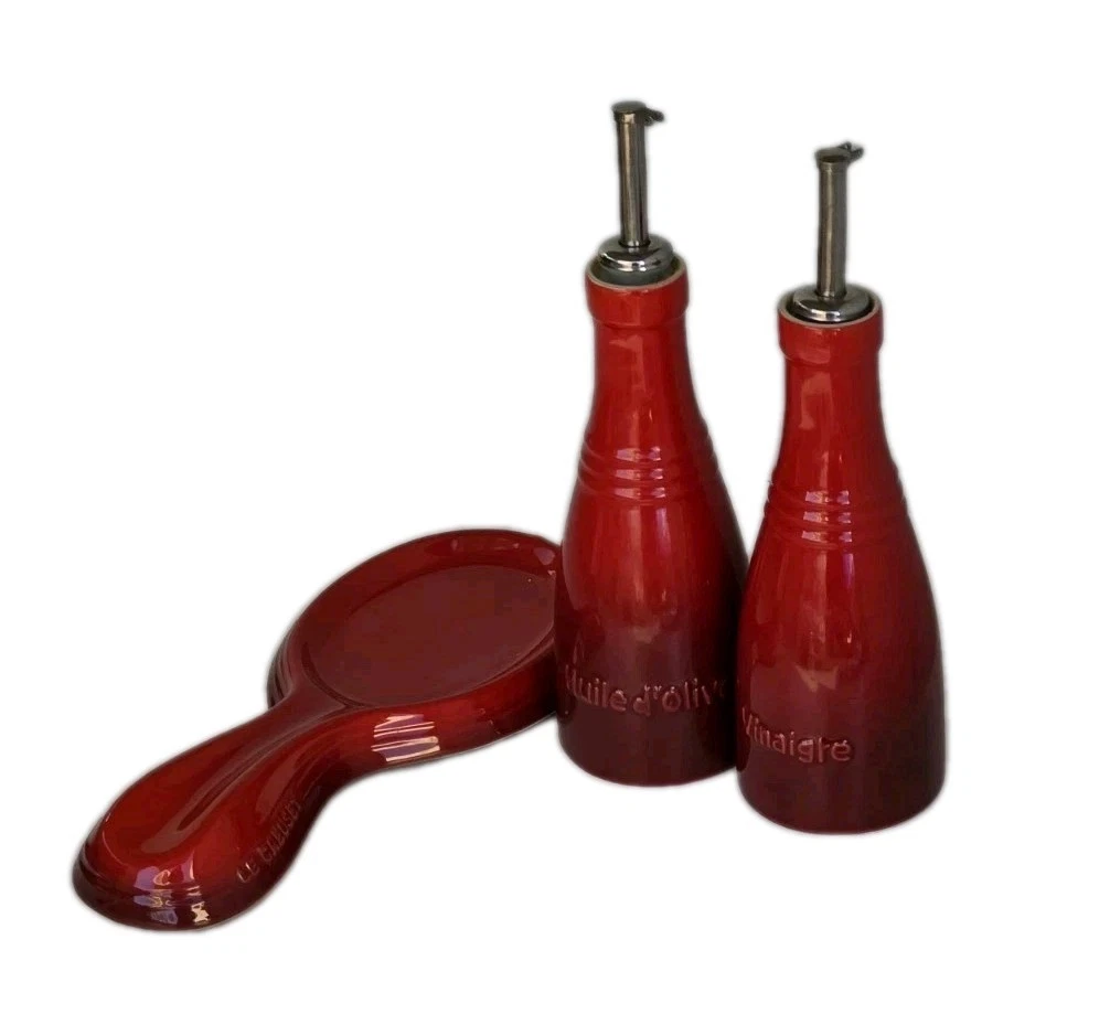 Le Crueset Cerise Red Ceramic Oil & Vinegar Bottle Set Plus Spoon Rest.