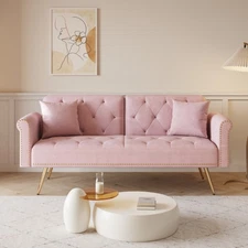 A 69.7-inch-long sofa bed covered in pink velvet fabric, featuring nail head tri