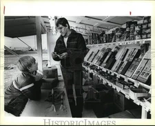 1987 Press Photo John Chadwick listens as Robert Theis shows available fireworks