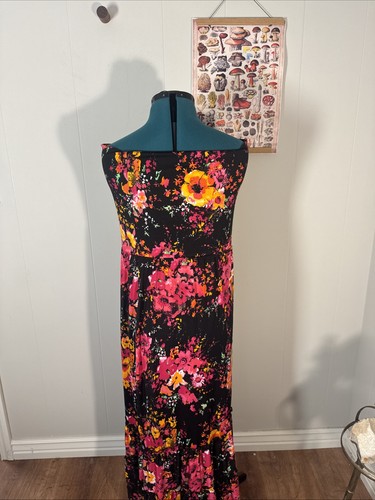 Black stretch maxi tube dress with pink, red, and yellow floral print, displayed on mannequin against white wall.