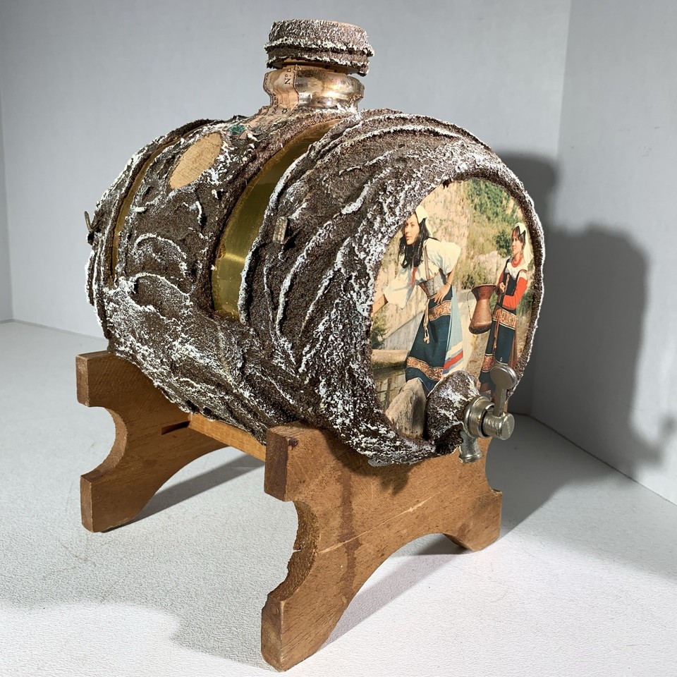 A vintage Italian tap-barrel liquor decanter combining wood, brass, glass, and ceramic into a gloriously over-engineered piece of Old World barware theater.