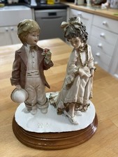 A signed Porcelain Figurine By A Belcari 1984 Dear Arnot Boy Girl Dressing Up.