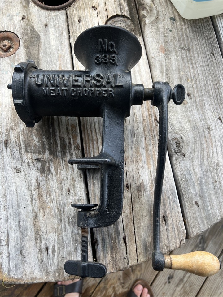 A fully working vintage cast-iron hand-crank meat grinder — the kind of serious, satisfying old-world kitchen tool that makes modern gadgets look feeble.