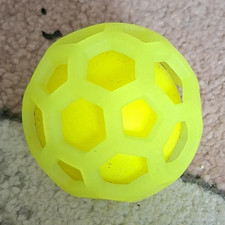 Hundespielzeug Ball gelb aus Gummi mit Gitterh&uuml;lle/Wabenmuster hohl