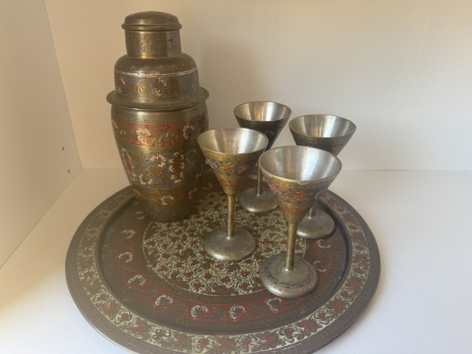 A brass cocktail shaker, tray, and cups set from India with genuine antique character — a conversation-starting bar setup with serious old-world exotic flair.