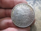 1886 O US MORGAN SILVER DOLLAR IN ABOUT UNCIRCULATED CONDITION