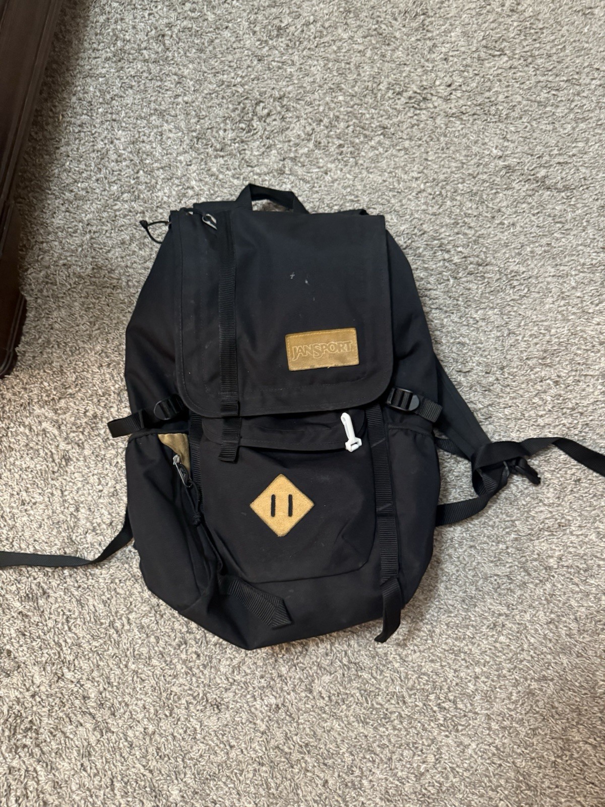 Black and tan Jansport backpack, it's making use 80 letters so i'm just yapping