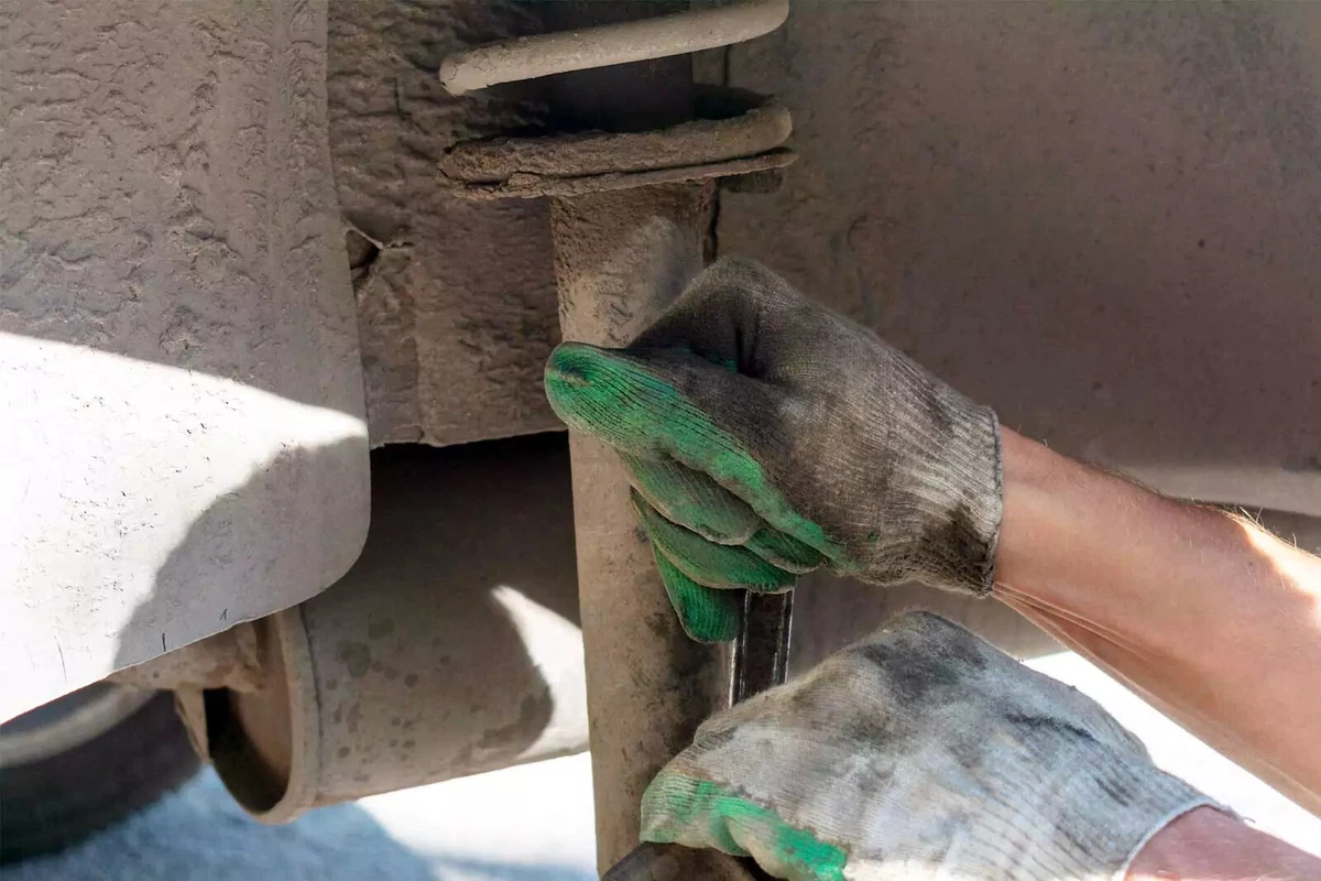Loosening a vehicle's shock absorber as part of a DIY shock absorber replacement.