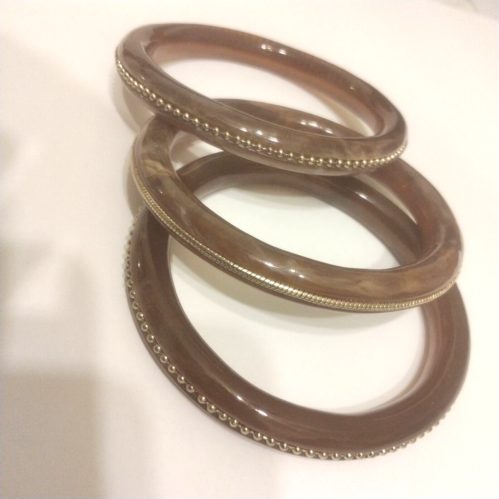 Three Hard Plastic Bangle Bracelets with Goldtone Trim in Marbled Brown-image