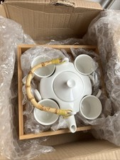 White ceramic nesting tea set teapot four cups, featuring bamboo-wrapped handle