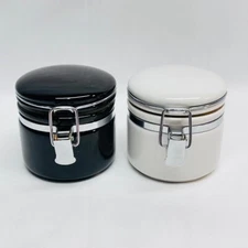 Two (2) OGGI Cannisters 1 Black - 1 White Clip Back Closure 2" D x 3" Dia x 3" H