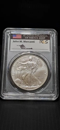 1999 SILVER EAGLE PCGS GEM UNCIRCULATED SIGNED BY JOHN M MERCANTI FLAG LABEL
