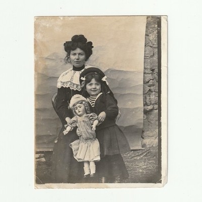 Junge Frau, kleines Mädchen und große Puppe - zerknitterterter bemalter Hintergrund und Wand - 1911