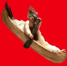 NATIVE AMERICAN IN CANOE FIGURINE WITH FURS AND TRADE 14 1/4" CARSON