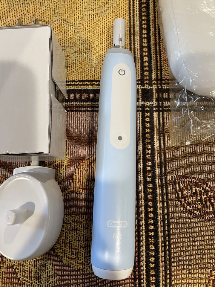 Cepillo de dientes eléctrico Oral-B iO3 con cabezal de cepillo Ultimate Clean y cargador azul helado Foto 2 de 4