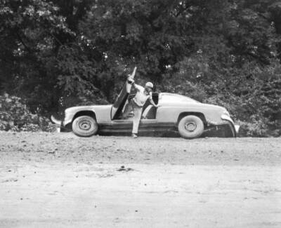 1950s driver exits car hurry finding himself very precarious posit- Old Photo