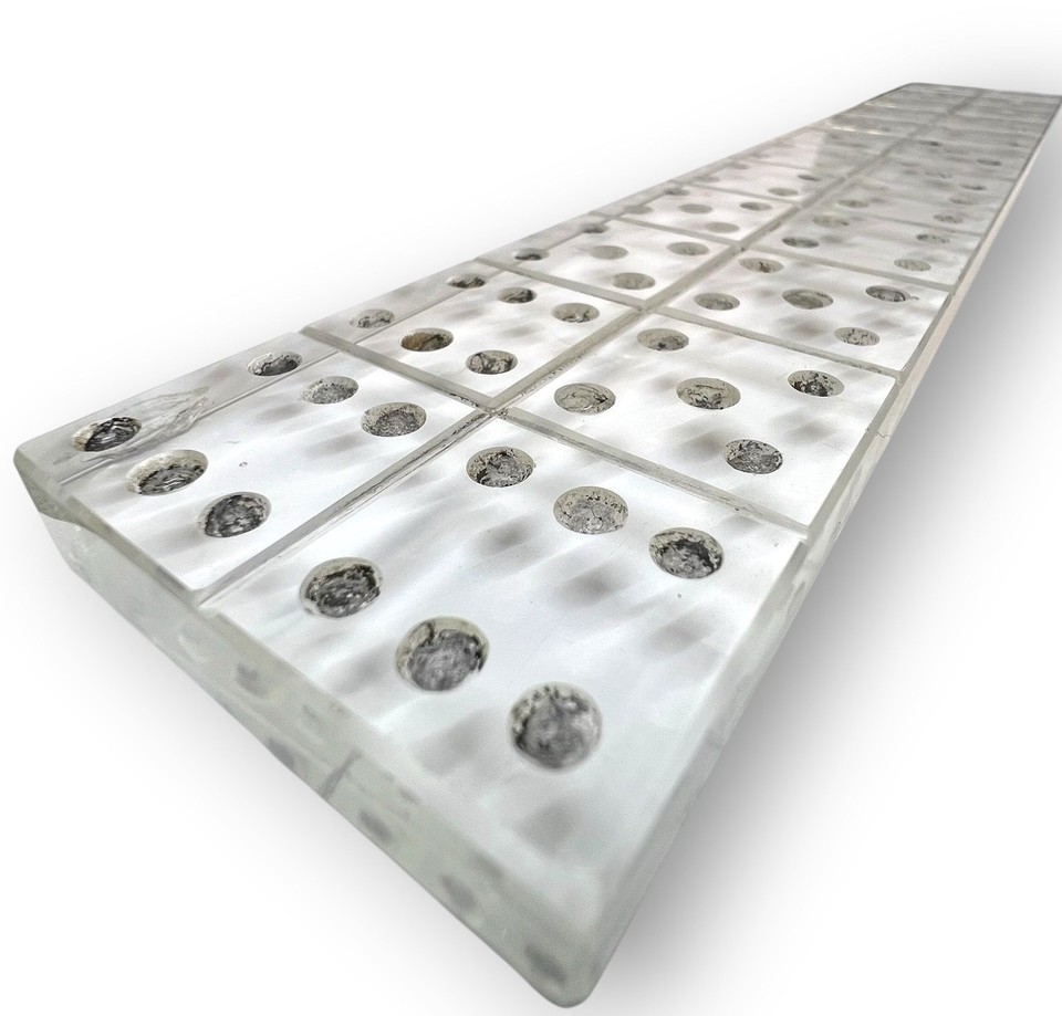 A clear glass ruler inlaid with a domino pattern — a MCM paperweight-meets-measuring-tool that's as visually intriguing as it is useful.