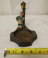 vintage cast iron ashtray lady leaning on pole with a rolling pin Table Top