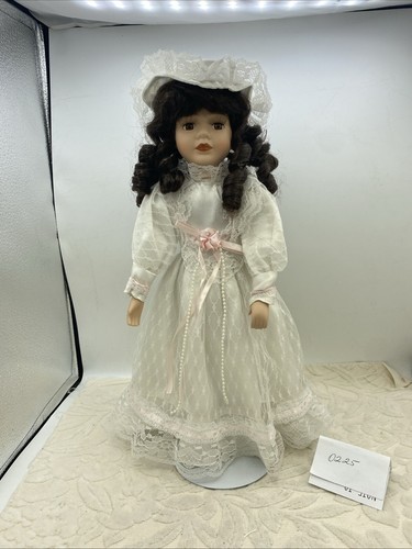 16 Zoll Porzellanpuppe mit weißem Kleid/Hut, braune Locken, braune Augen. Inklusive Ständer