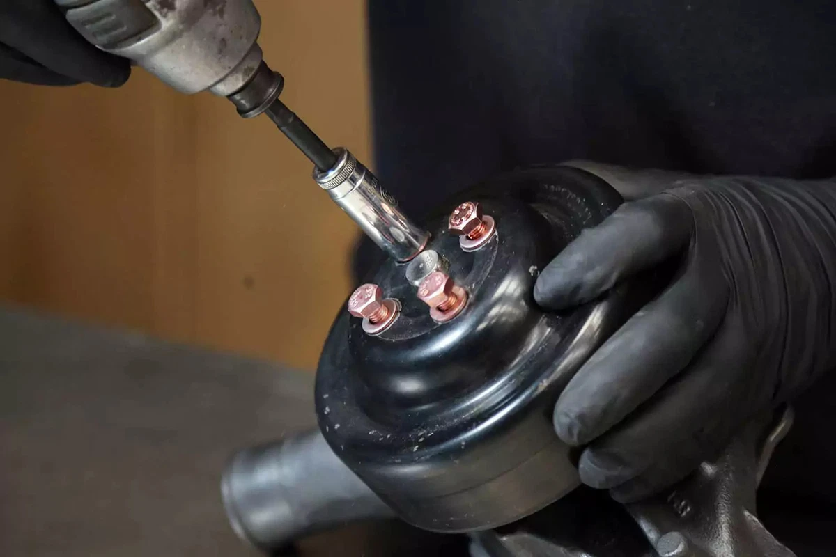 Bolting the original pulley to the new water pump with an impact wrench.