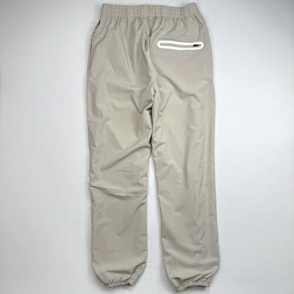 Pantalones de chándal New Balance cortavientos para hombre talla M beige forrados reflectantes Foto 3 de 4