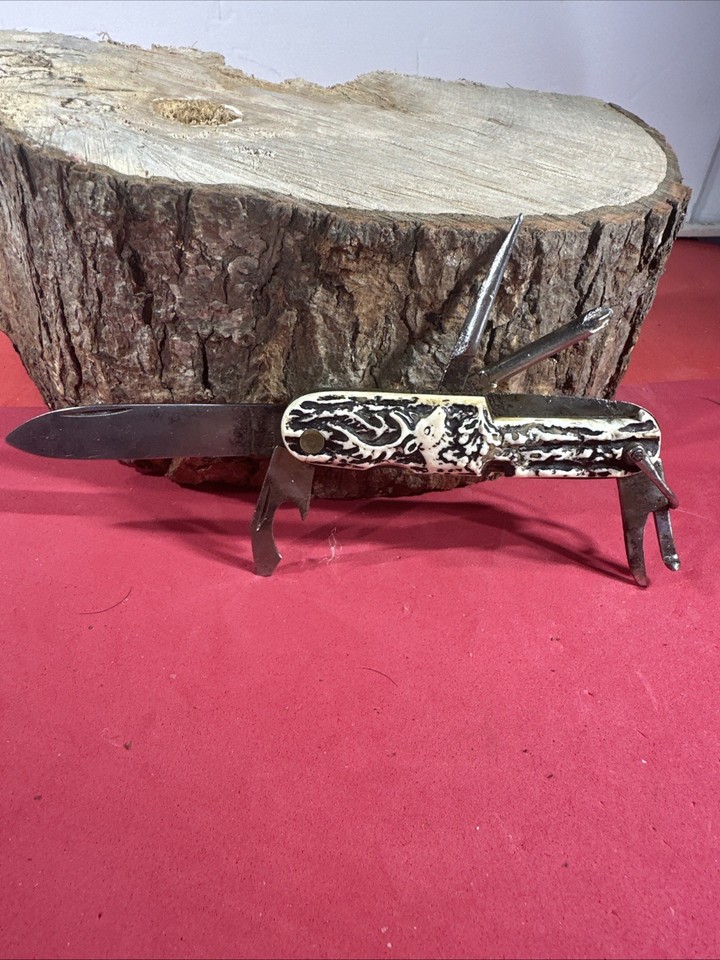 A German-made multi-tool pocket knife with a hand-carved deer scene handle — functional antique art you can actually carry.