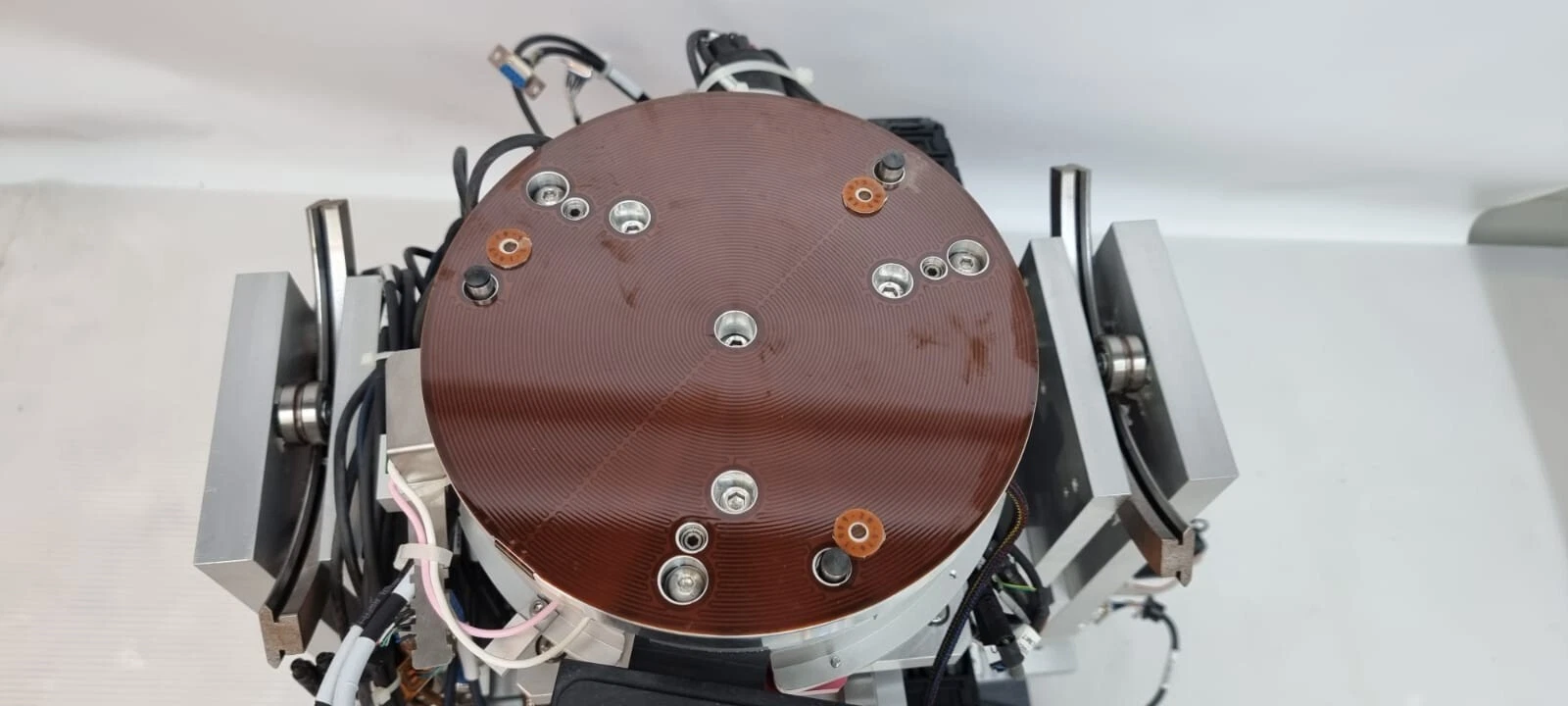 Top view of the round grooved stage plate with locating pins between the tilt guides