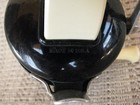 Black Zebco 202 spin casting reel with white handle, made in U.S.A., etched on side handle.