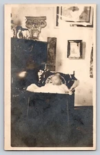 RPPC baby in crib Livingroom fireplace parlor Postcard Portrait Real Photo
